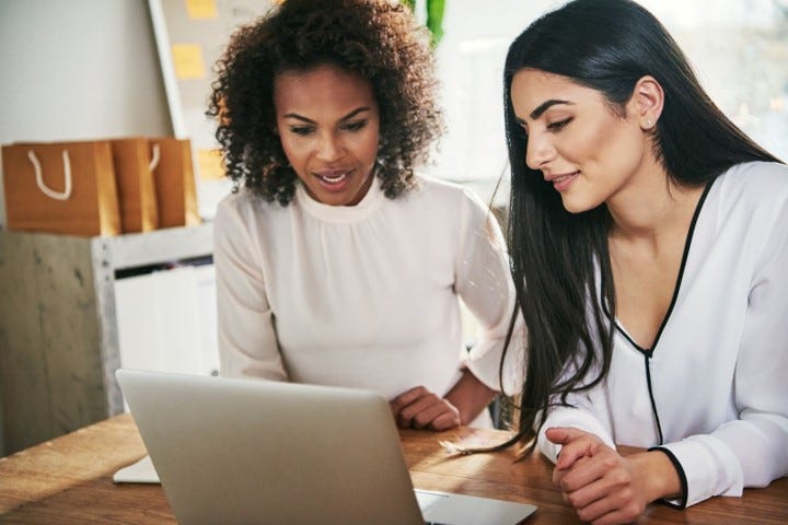Two women dressed in business casual attire working together..jpg
