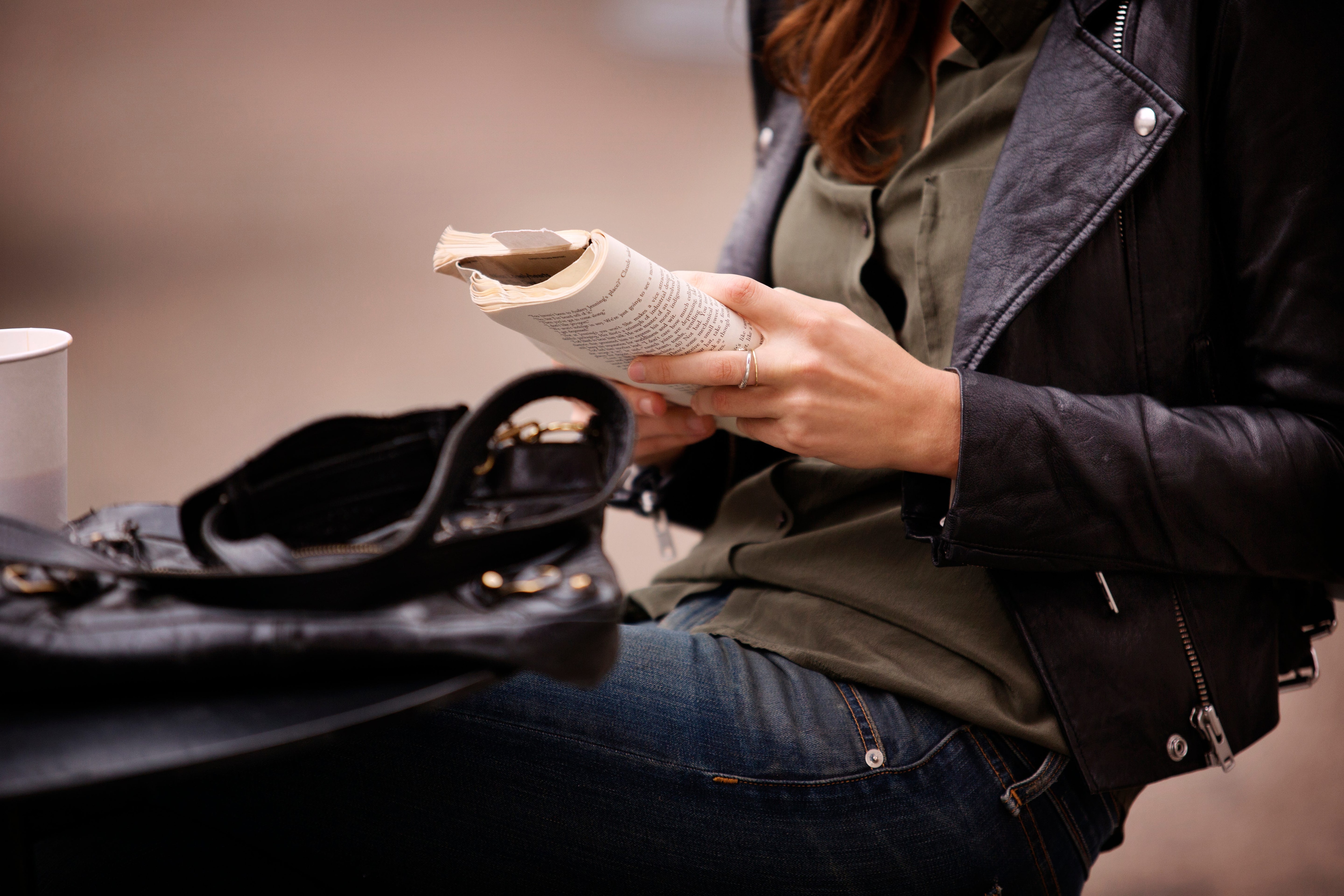 Woman wearing a leather jacket reading a book.jpeg